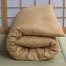 Folded Japanese double futon with organic cotton filling, in light brown