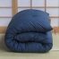 Folded single Japanese futon with organic cotton filling in dark blue